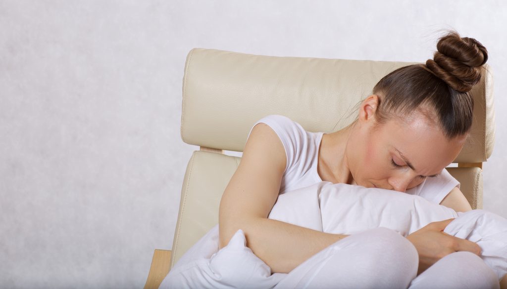 Young caucasian lady between 30 and 40 years old is sitting in the armchair. Closeup