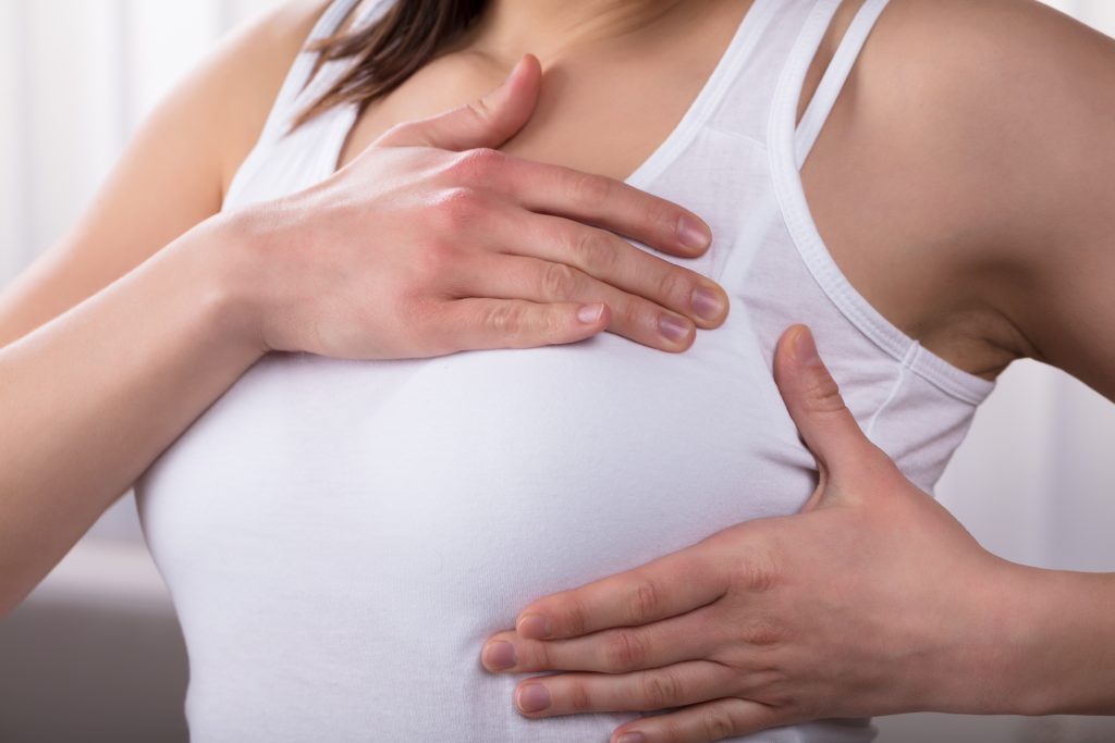 Close-up Of A Woman's Hand On Breast Suffering From Pain