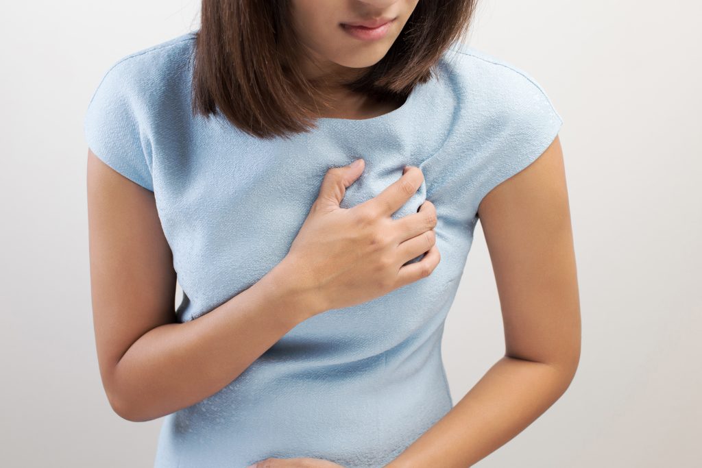 Woman is clutching her chest, acute pain possible Heart attack