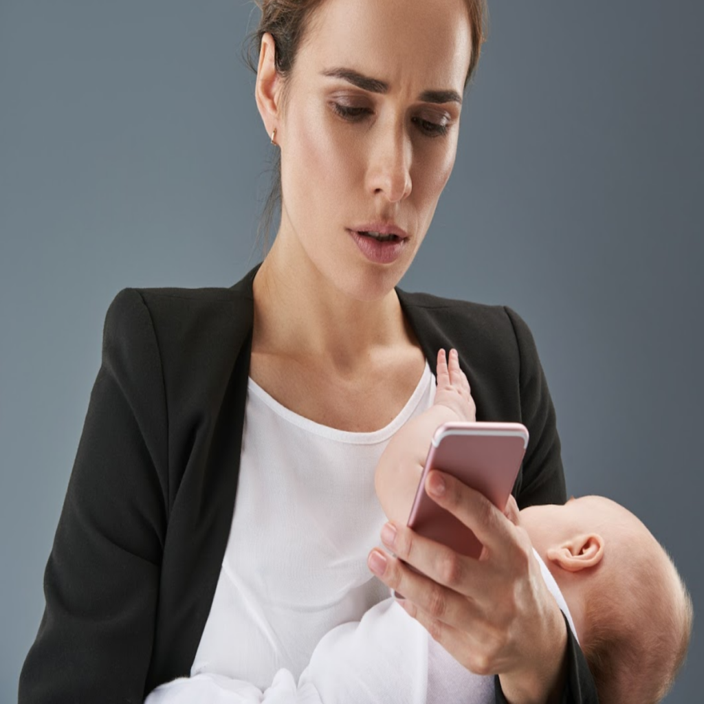 mom on phone while nursing baby