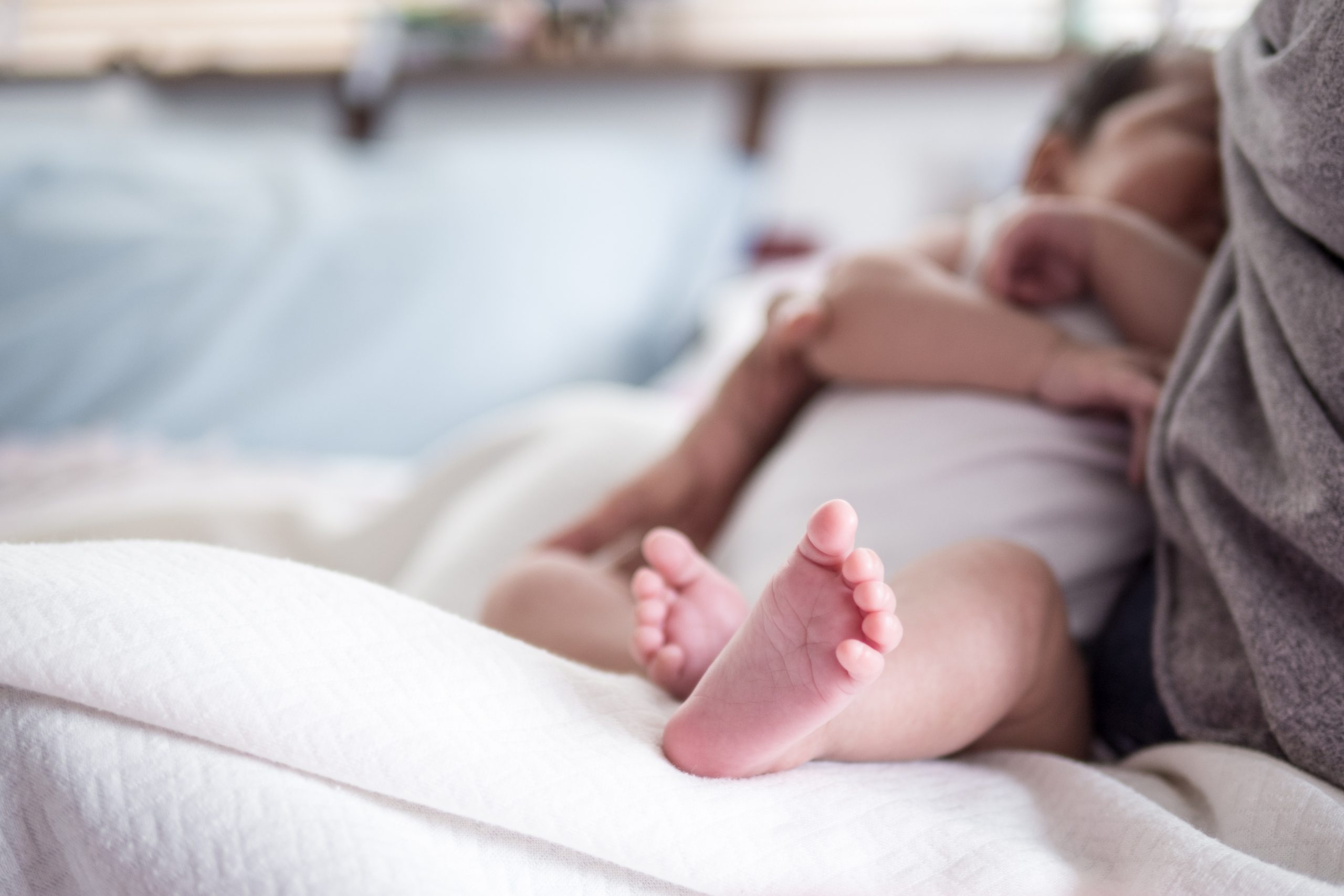 baby laying on mother nursing