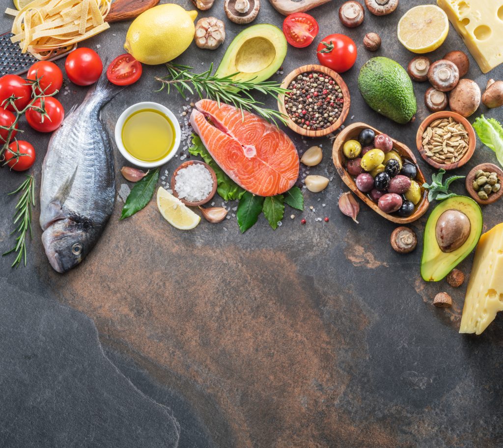 RAW DORADO FISH AND SALMON STEAK WITH SPICES AND VEGETABLES ON THE GRAPHITE BOARD. TOP VIEW.