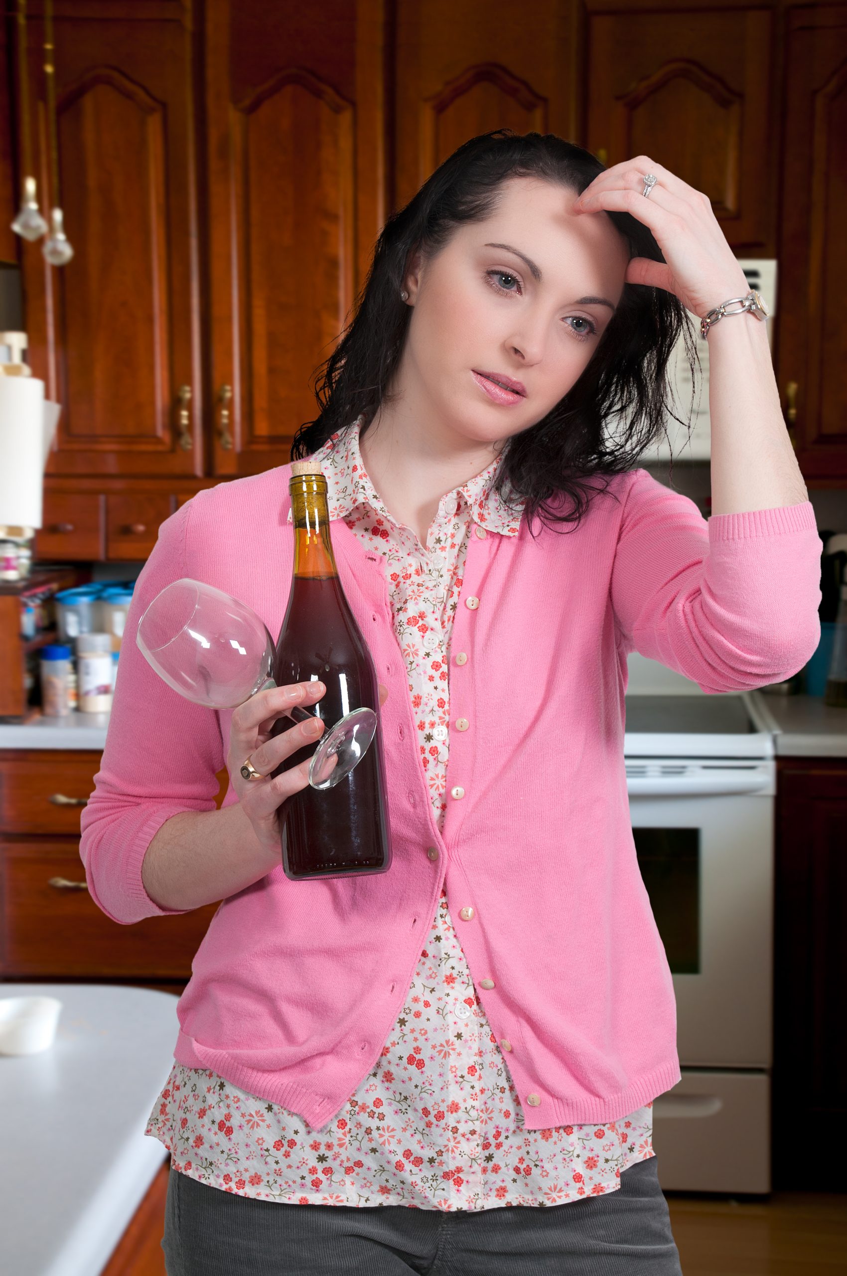 confused woman with bottle of alcohol